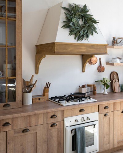 Natural wood cabinetry with black metal hardware, adding a warm and traditional aesthetic.