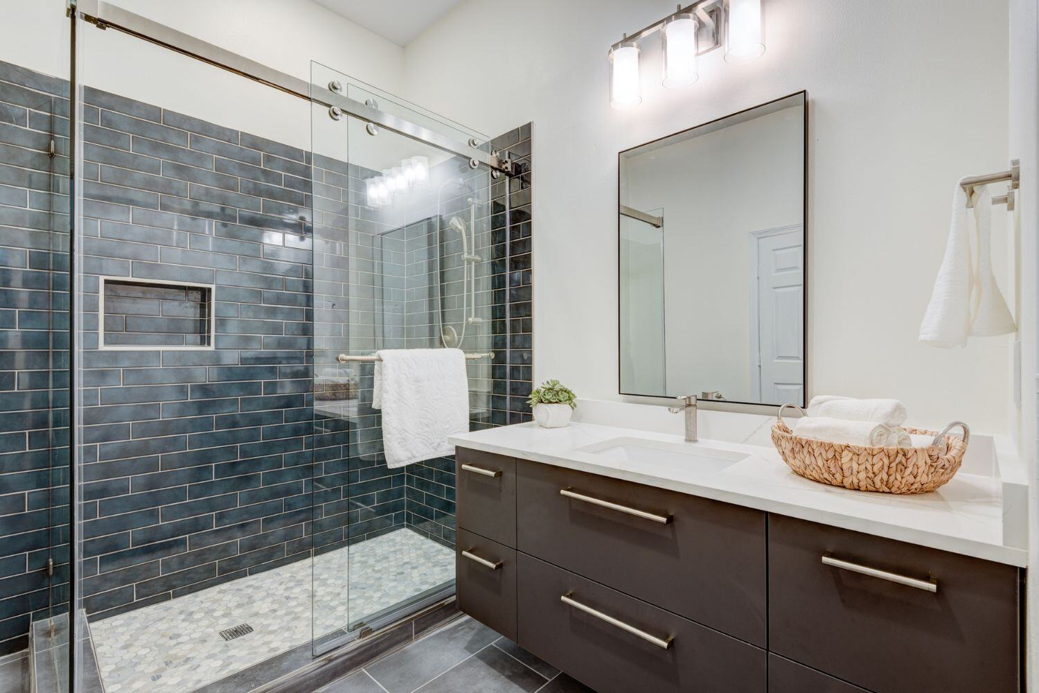 Bathroom Remodel in Greater Houston with floating bathroom vanity and frameless shower doors